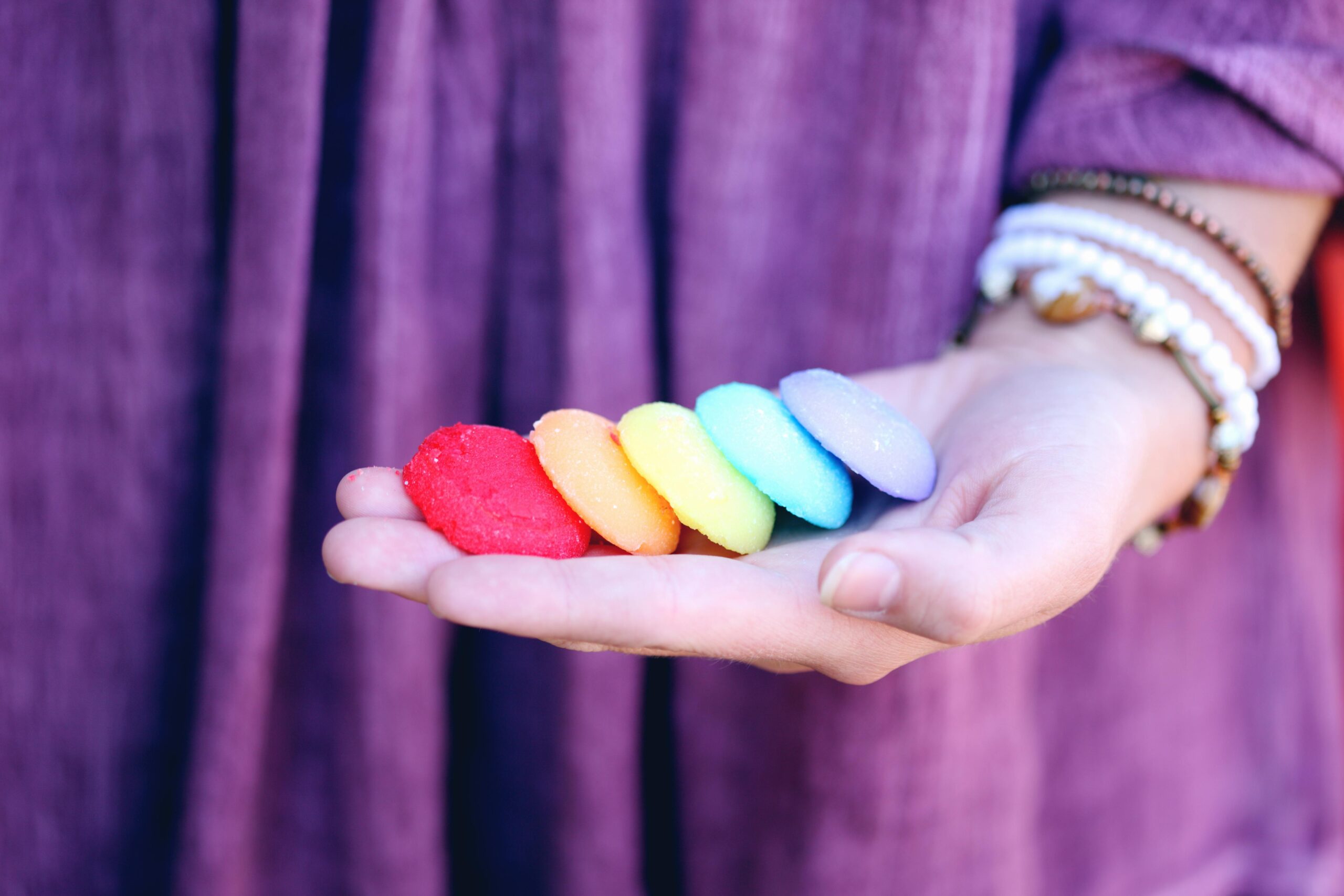 Vibrant rainbow cookies on an open hand symbolizing LGBT pride and diversity.