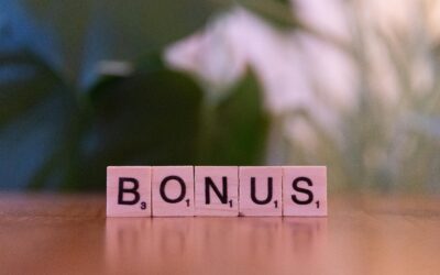 Close-up of the word BONUS spelled with Scrabble tiles on a table.